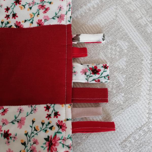 Rožinės ir raudonos spalvos skiautinių antklodė- dekoracija vaiko kambariui.